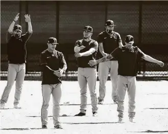  ?? Charlie Riedel / Associated Press ?? Rangers players gather to stretch on Friday in Surprise, Ariz. The Rangers will play the Royals on Sunday.