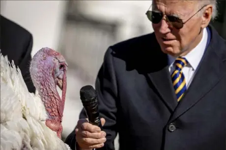  ?? Andrew Harnik/Associated Press ?? President Joe Biden holds the microphone to Chocolate, the national Thanksgivi­ng turkey, during a pardoning ceremony Monday at the White House in Washington.