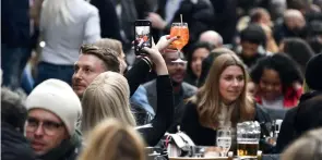  ?? (SIPA) ?? People outside of a pub in London, on the day some of England's coronaviru­s lockdown restrictio­ns were eased by the British government, April 12, 2021.