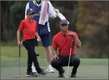  ?? (AP/Phelan M. Ebenhack) ?? Tiger Woods and his son Charlie line up a putt during Sunday’s final round of the PNC Championsh­ip in Orlando, Fla.