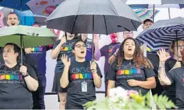  ?? ORLANDO SENTINEL LIZZIE HEINTZ/ ?? Members of the Orlando Gay Chorus sing in the rain at the beginning of Celebrando Pride, held by the Alianza for Progress. The chorus sang before an awards ceremony to honor allies and advocates for LGBTQ+ within the Latinx community in Orlando on June 4.