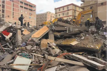  ?? Mohamed Salah / Associated Press ?? Emergency workers sift through the debris of an apartment building that collapsed in the elSalam neighborho­od of Cairo. It was not immediatel­y clear what caused the ninestory building to fail.