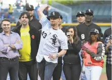  ?? David Banks / Associated Press ?? Danny Farquhar, recovering from a brain hemorrhage, throws the ceremonial first pitch before the White Sox-Brewers game.