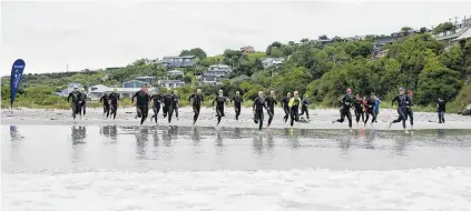  ?? PHOTOS: CHRISTINE O’CONNOR ?? And they’re off . . . Competitor­s sprint for the waves at the start of the Otago Triathlon Championsh­ip at Brighton Beach yesterday.