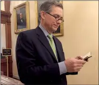  ?? Arkansas Democrat- Gazette/ FRANK E. LOCKWOOD ?? U. S. Rep. French Hill consults a copy of the U. S. Constituti­on outside the House chamber Thursday to show the passage he read earlier on the House fl oor.