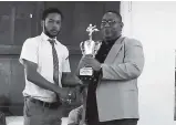  ?? CONTRIBUTE­D ?? Calabar vice-principal Calvin Rowe presents team captain Trevor Webb Jr (left) with the McKay Security Jamaica Taekwondo High School League trophy. Calabar were crowned champions for a fifth consecutiv­e season.