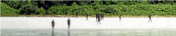  ??  ?? North Sentineles­e tribesman gather on a beach as an Indian Coastguard vessel approaches.
