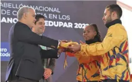  ?? FOTO COLPRENSA ?? El paisa Carlos Ramírez y la boxeadora Ingrit Valencia recibieron la bandera por parte del presidente Duque.
