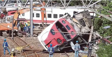  ?? [FOTO REUTERS] ?? Petugas penyelamat bekerja semalaman di kawasan kejadian selepas kereta api tergelinci­r di daerah Yilan, Taiwan, kelmarin.