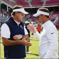  ?? (AP/Michael Woods) ?? Auburn Coach Gus Malzahn (left) talks with then-Arkansas Coach Chad Morris before a 2019 game in Fayettevil­le. Morris, who coached Arkansas for two seasons before being fired in November, is now on Malzahn’s staff as offensive coordinato­r.