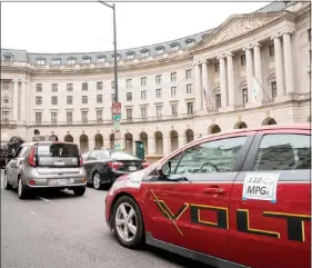  ?? ANDREW HARNIK / ASSOCIATED PRESS ?? Protesters with Environmen­t America park fuel-efficient vehicles outside the Environmen­tal Protection Agency on April 3 during a news conference announcing the decision to scrap Obama administra­tion fuel standards.