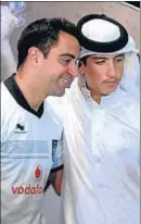  ?? ANADOLU AGENCY / GETTY ?? Xavi y un aficionado qatarí