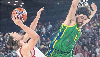  ?? GRAHAM HUGHES THE CANADIAN PRESS ?? Canada’s Kelly Olynyk, left, going up against Anderson Varejao, had 20 points and 18 boards in the World Cup qualifier.