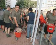  ?? (AFP) ?? Personnel from the Chinese People’s Liberation Army barracks in Hong Kong help the clean-up after a week of violence and disruption caused by pro-democracy protesters on Saturday.