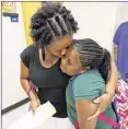  ??  ?? Latonya Davis gives her daughter Nailah Ruffin, 10, a hug goodbye at her fifth-grade classroom at Bouie Elementary School on Monday.