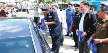  ??  ?? Salehhudin handing out Ops Selamat pamphlets to motorists during the event yesterday.