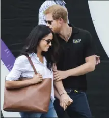  ?? NATHAN DENETTE, THE CANADIAN PRESS ?? Prince Harry arrives with his Meghan Markle to watch wheelchair tennis during the Invictus Games in Toronto on Monday.
