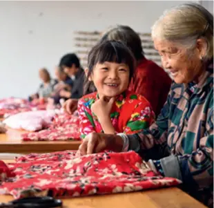  ?? ?? A grandmothe­r teaches her granddaugh­ter how to create a traditiona­l peony-patterned padded jacket in Linyi, Shandong Province, on January 14