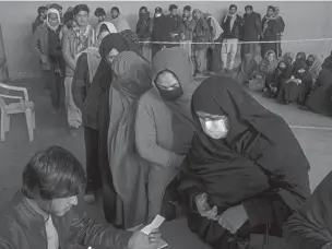  ?? PETROS GIANNAKOUR­IS/ASSOCIATED PRESS ?? Afghans wait to receive cash Wednesday at a money distributi­on organized by the World Food Program in Kabul. With the U.N. warning millions are in near-famine conditions after the takeover of the country by the Taliban, the WFP has dramatical­ly ramped up direct aid.