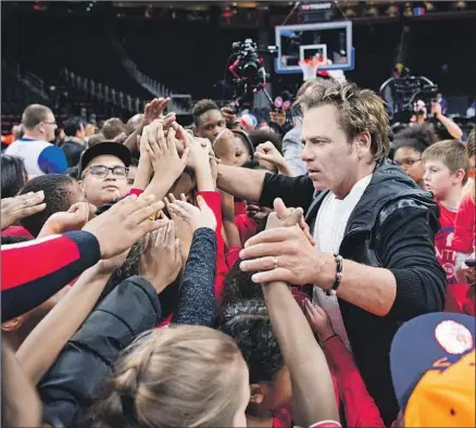  ?? Mike Ferdinande ?? PLATINUM EQUITY’S Tom Gores, with kids on the court in 2017, has been criticized for his purchase of Securus Technologi­es.