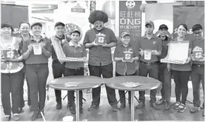  ??  ?? MASTER ONG (tengah) bergambar bersama hidangan ayam Bucket yang menyelerak­an bersama kakitangan SugarBun di Boulevard Shopping Mall semalam.