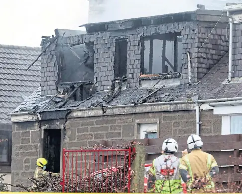  ??  ?? AFTERMATH: Firefighte­rs inspect the fire damage in Stewart Street, just off Coupar Angus Road in Lochee, Dundee. Picture by Gareth Jennings.