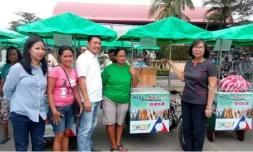  ?? — Princess Clea Arcellaz ?? NEGOKARTS. Apalit Mayor Peter Nucom and DOLE Pampanga Director Arlyn Cortez together with her staff in posterity during the distributi­on of NegoKarts to the beneficiar­ies at the municipal grounds.