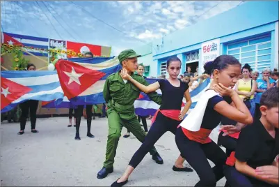  ?? ALEXANDRE MENEGHINI / REUTERS ?? Fidel Castro fan Marlon Mendez, 11, is dressed in a military uniform as he takes part in a dance performanc­e as part of the celebratio­ns for what would have been the late Cuban president’s 91st birthday in San Antonio de los Banos.