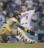  ?? Marcio Jose Sanchez Associated Press ?? FREDDIE FREEMAN slides in for one of his three runs scored. Freeman was three for three as a hitter.