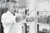  ?? AFP PHOTO ?? Karate master Mamoru Nakamoto, a high-ranking expert of the Okinawa Kobudo traditiona­l weapons system, using a pair of “sai” to demonstrat­e his skills at a training hall in Naha, Okinawa prefecture.