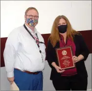  ?? Janelle Jessen/Herald-Leader ?? Principal Jacob Hayward (left) presents the middle school teache rot the year award to Melissa Cluck during Thurs-days school board meeting.