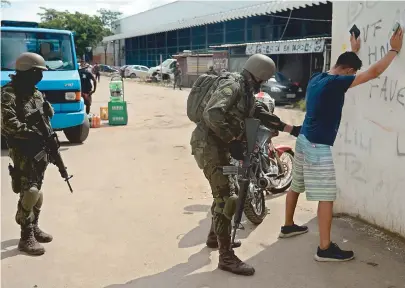  ??  ?? Os militares revistaram moradores da Kelsons durante a operação na favela