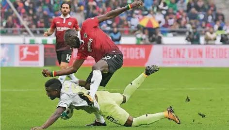  ?? FOTO: DPA ?? Bodenturne­n: Jhon Cordoba (Köln, unten) und der Hannoveran­er Verteidige­r Salif Sané bemühen sich um den Ball.