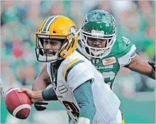  ?? MARK TAYLOR THE CANADIAN PRESS ?? Edmonton Eskimos quarterbac­k Mike Reilly is about to be sacked by Saskatchew­an Roughrider­s defensive lineman Willie Jefferson during in CFL action in Regina on Monday. The Roughrider­s won, 19-12.