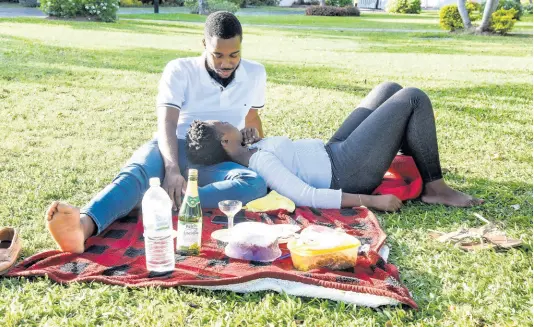  ?? NICHOLAS NUNES/PHOTOGRAPH­ER ?? Amish Bloomfield (left) and Shannon March enjoy an afternoon picnic on the lawns of Emancipati­on Park in New Kingston on Valentine’s Day Sunday. Coronaviru­s concerns muted the traditions of high-traffic brunches and cinema dates, sending a painful arrow through the hearts of many merchants who usually cash in on the day of love.