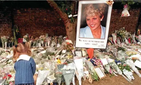  ?? PHOTO: PAUL VICENTE ?? A young girl adds to the floral tributes beneath a large photo of Princess Diana outside Kensington Palace in London after her death.