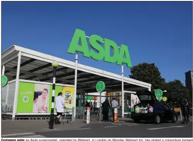  ?? (Bloomberg News/Simon Dawson) ?? Customers enter an Asda supermarke­t, operated by Walmart, in London on Monday. Walmart Inc. has picked a consortium backed by TDR Capital as the preferred bidder for a majority stake in Asda, people with knowledge of the matter said.