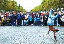  ??  ?? PEOPLE WATCH A PERFORMANC­E during the “day without cars” in Paris. / AP FOTO