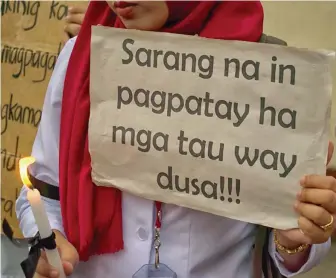  ?? (Mindanao Examiner photo - Neza Gariando) ?? A Muslim student holds a placard that reads “Stop killing innocent people” during a protest on extrajudic­ial killings.