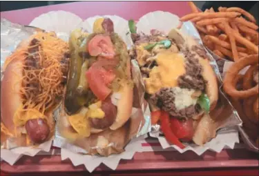  ?? GARY PULEO — MEDIANEWS GROUP ?? Popular menu items at Pink’s include, from left, Chili Cheese Dog, Chicago Polish Dog and the Philly Cheesestea­k Dog.