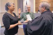  ?? ADOLPHE PIERRE-LOUIS/JOURNAL ?? Rio Rancho school board member Wynne Coleman, center, takes the oath of office with the help of her friend Hope Garcia and Judge Louis McDonald on Monday.