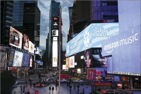  ?? JOHN MINCHILLO — THE ASSOCIATED PRESS ?? A screen displays a message thanking health care workers during the coronaviru­s outbreak, in a sparsely populated Times Square, Friday, March 20, 2020, in New York. New York Gov.