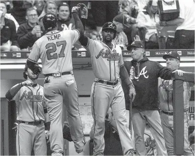  ?? Associated Press ?? Atlanta Braves’ Matt Kemp gets a high-five from teammates after hitting his second home run against the Milwaukee Brewers on Saturday in Milwaukee.