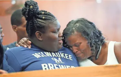  ?? MICHAEL SEARS / MILWAUKEE JOURNAL SENTINEL ?? Baron Walker’s wife, Beverly Walker (right), and daughter, Wisdom Walker, embrace as Milwaukee County Judge Mark Sanders modified Walker’s sentence on bank robbery charges, allowing him to be released on probation and live with his family. More photos at jsonline.com.