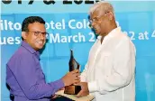  ?? ?? Upali Wijewarden­e Feature Writer of the Year (2020-English stream): Sandun Jayawardan­a of the Sunday Times receives the award from Nimal Welgama, Managing Director Upali Newspapers (Pvt) Limited