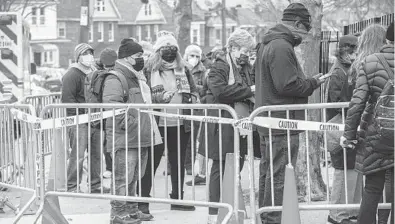  ?? HIROKO MASUIKE/THE NEW YORK TIMES ?? Americans wait in line to receive the coronaviru­s vaccine Jan. 13 in the Queens borough of New York City. Optimism about the COVID-19 vaccines may be lifting the stock market to record highs.