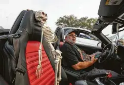  ??  ?? Grant Petty keeps an eye on his passenger “Spooky” as he prepares to take part in a car club cruise.