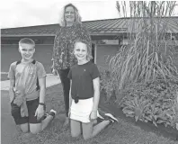  ?? SHANE FLANIGAN/THISWEEK ?? Fifth-graders Matthew Moore, 11, and Sophia Koltak, 10, along with gifted-interventi­on specialist Christine Hernon are shown next to the rain garden at Brown Elementary School on Sept. 14 in Hilliard. Hernon started the garden for the school, where second through fifth-grader have a hand in its upkeep.