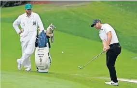  ?? [AP PHOTO/CHARLIE RIEDEL] ?? Caddie Nick Heinen watches as Matthew Wolff chips to the sixth green Friday at The Masters in Augusta, Ga.