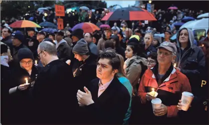  ?? / AP-Matt Rourke ?? People hold candles as they gather for a vigil in the aftermath of a deadly shooting at the Tree of Life Synagogue, in the Squirrel Hill neighborho­od of Pittsburgh on Saturday.